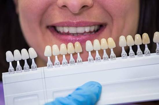 Consultório odontológico com acabamento em madeira e luz indireta quente, associado à especialidade de Estética